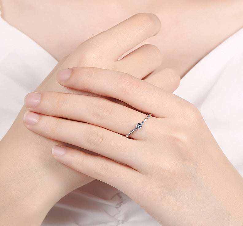 0.06 CTW DEW round brilliant moissanite ring in platinum plated sterling silver on hand