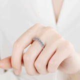 0.7 CTW DEW seven-stone round moissanite semi-eternity band in platinum plated sterling silver on hand