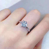 0.8 carat colorless round brilliant cut moissanite solitaire engagement ring in sterling silver with pave set accent stones on hand