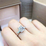 1.8 CTW DEW emerald cut colorless moissanite three stone engagement ring with tapered baguette accents in 18K gold plated sterling silver