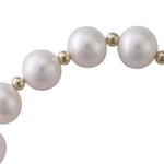 Close-up of white freshwater cultured pearls and 9k gold beads on a stretch bracelet