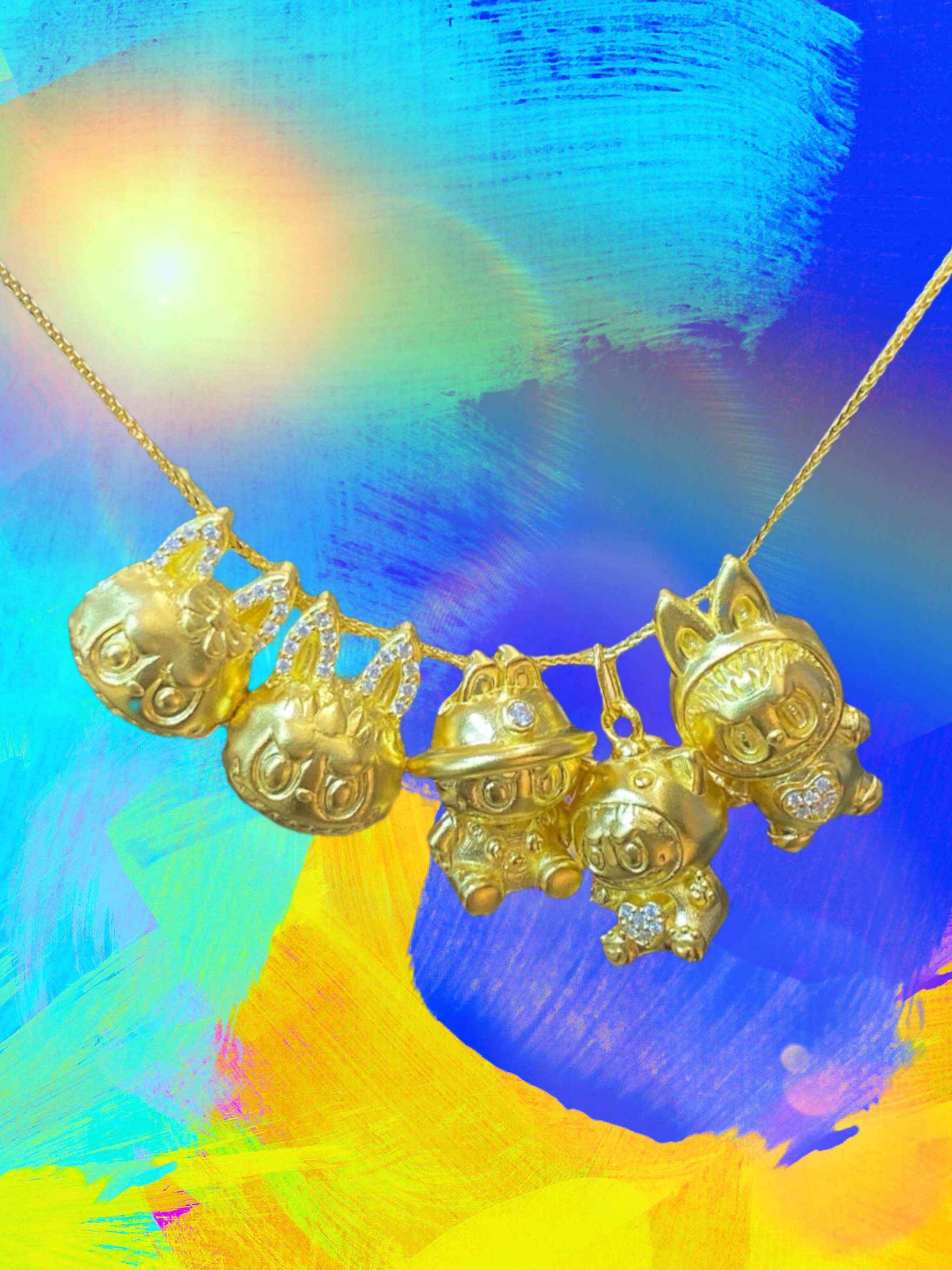 24K gold Labubu-inspired doll-head pendant necklace with sparkling moissanite stones on colorful background
