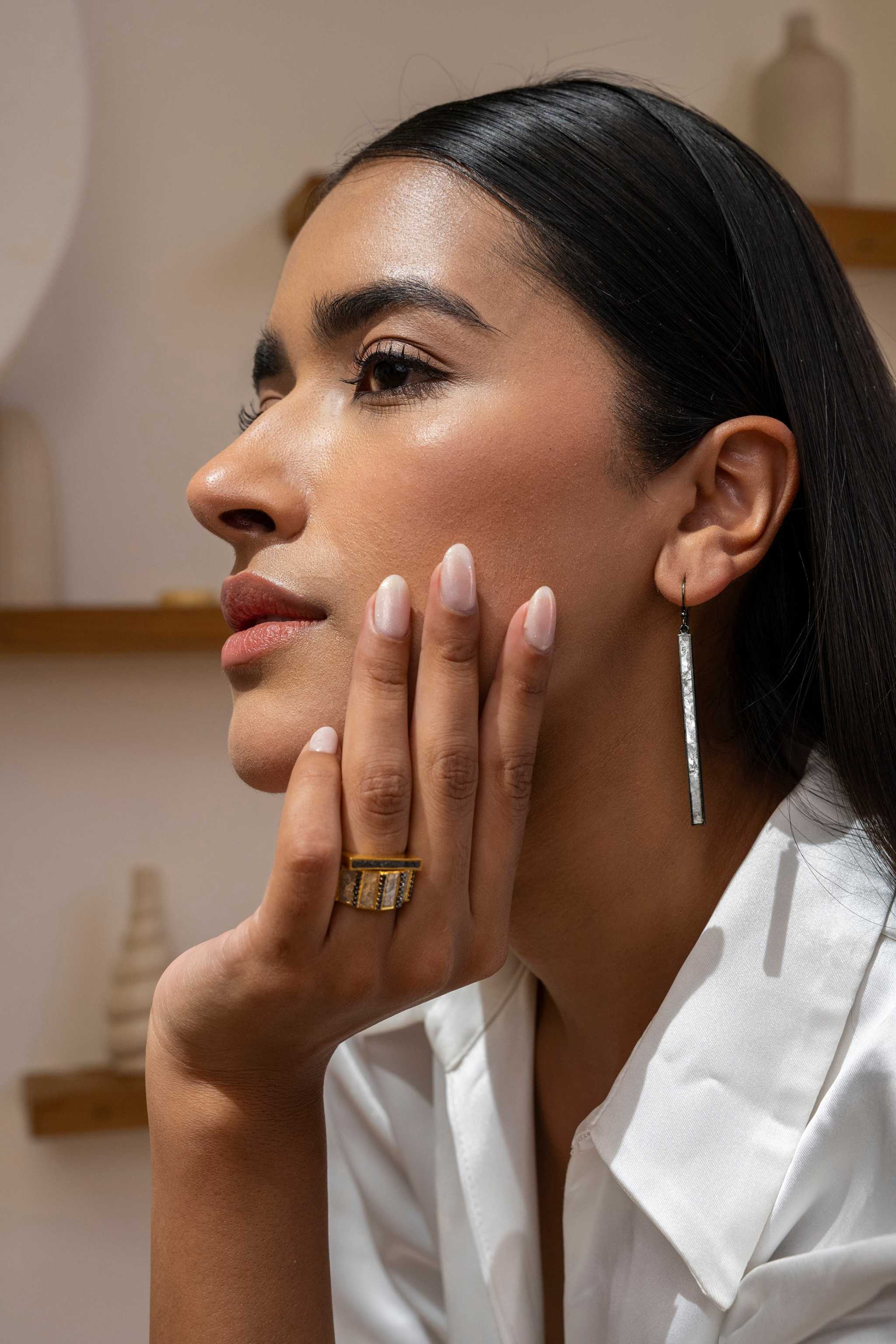 Woman wearing Miladi large oxidized silver long dangling earrings with raw uncut diamonds