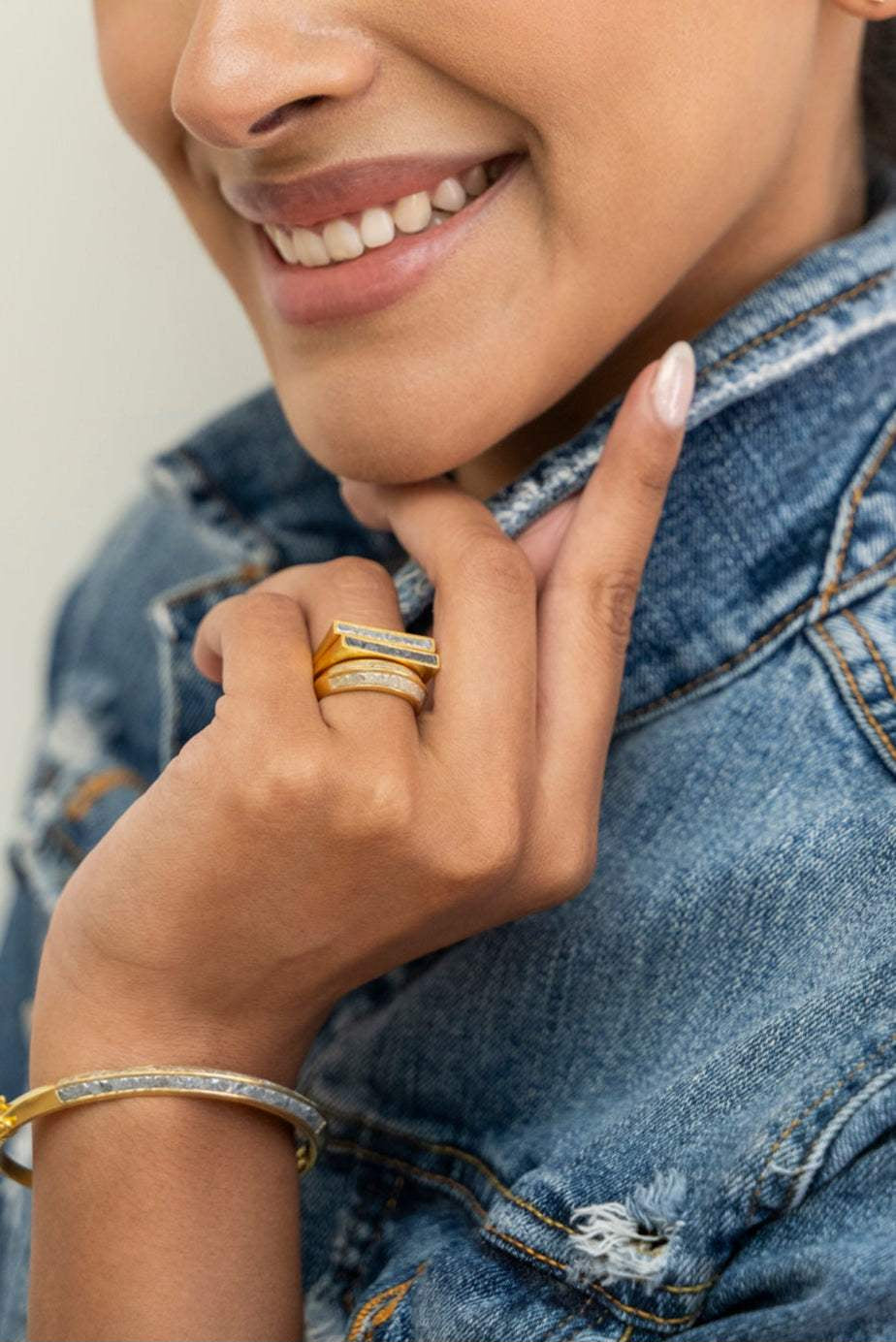 Michelle Gold Vermeil ring with thin diamond line and black diamond trim on woman's hand wearing denim jacket
