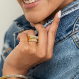Michelle Gold Vermeil ring with thin diamond line and black diamond trim on woman's hand wearing denim jacket