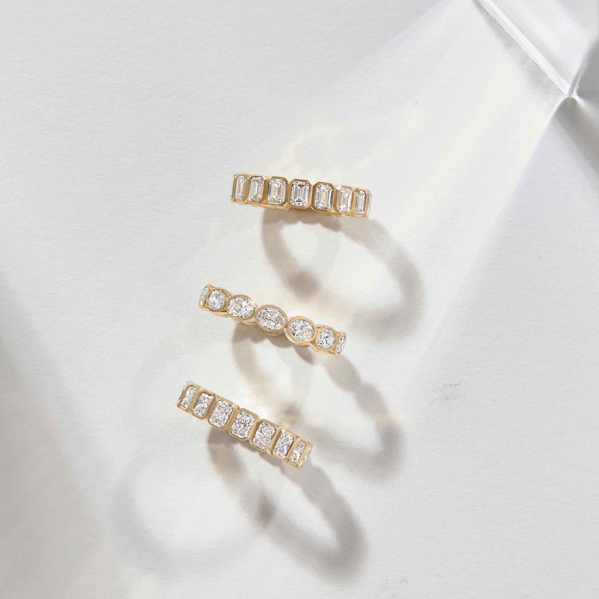 Solid gold bezel set emerald cut diamond eternity bands inspired by Nauset Light lighthouse