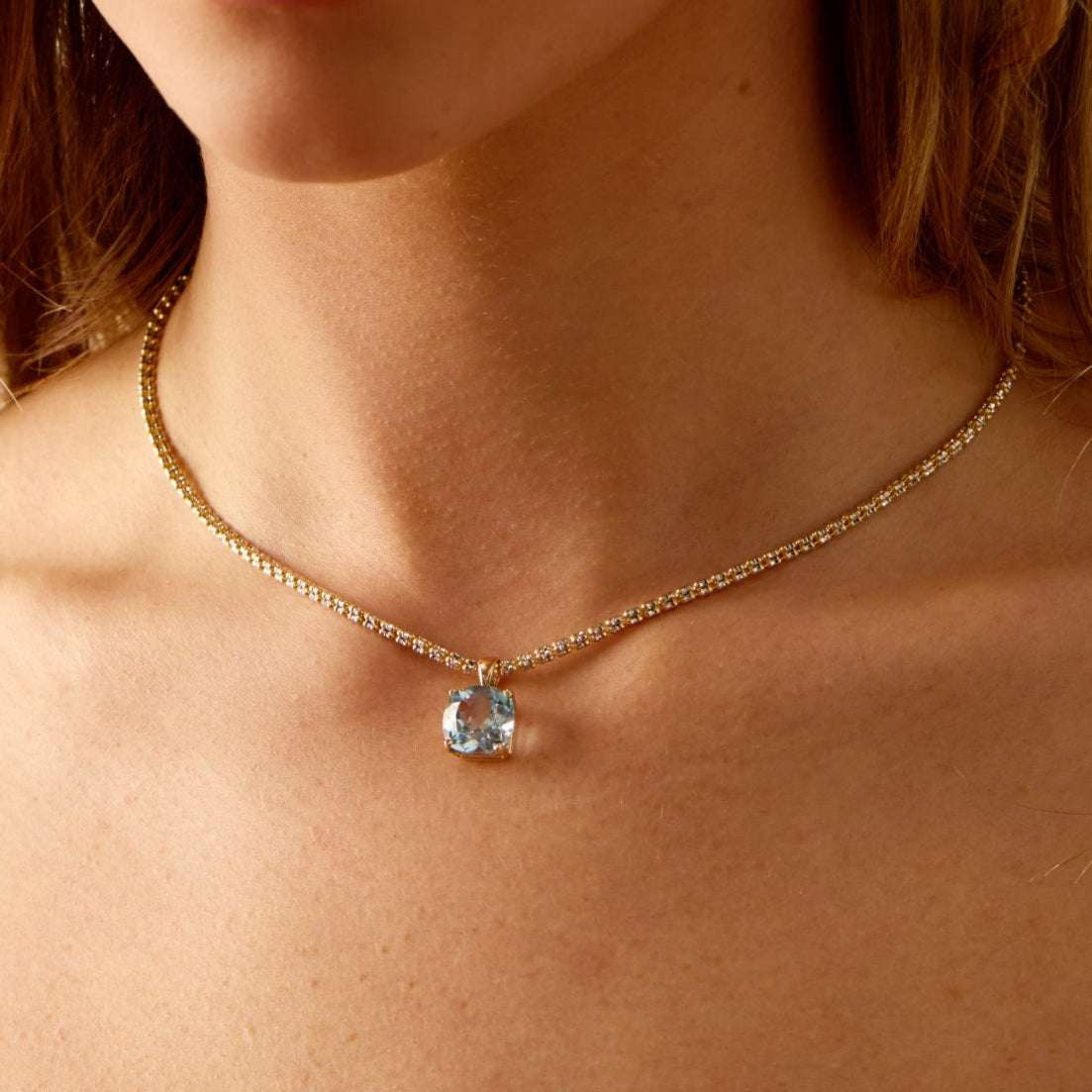Horizon Sky Blue Topaz pendant with 14k gold tennis chain on model's neck