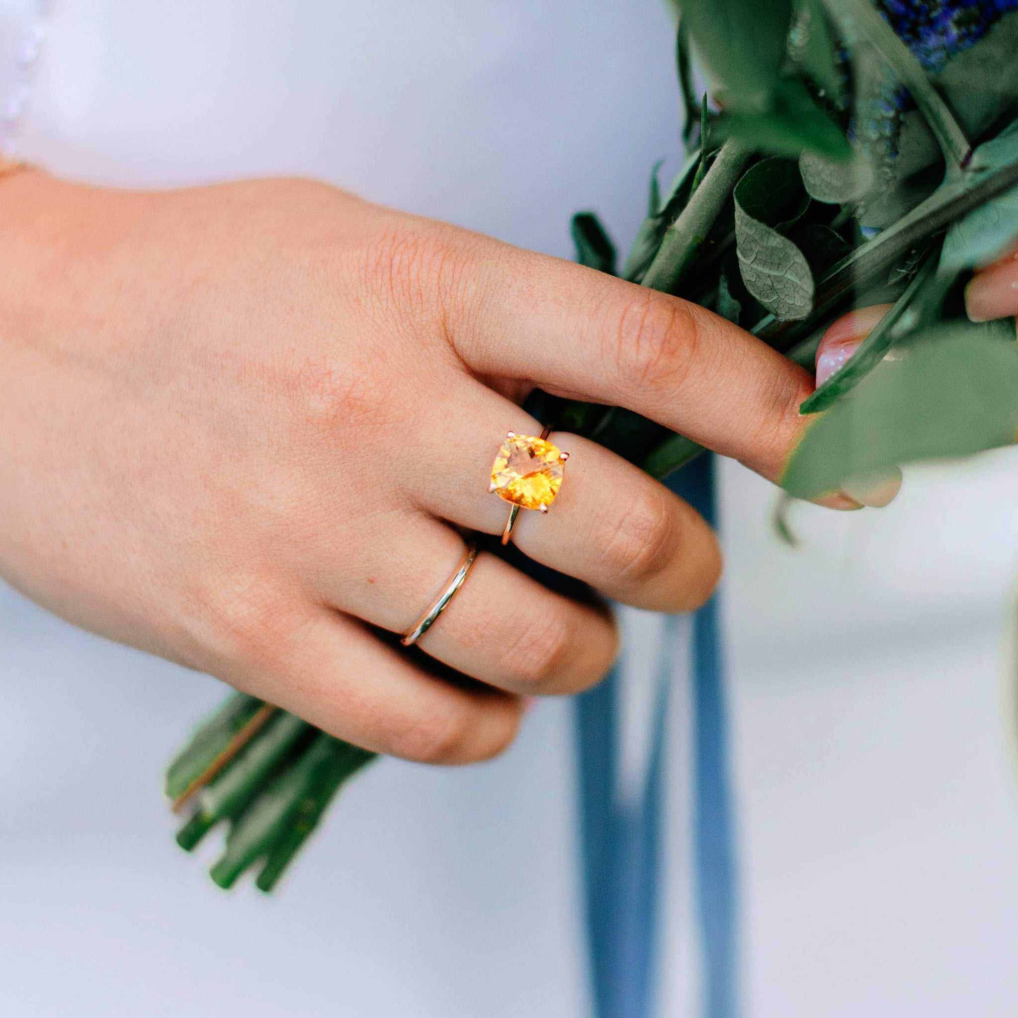 14k gold ring featuring a 10x10mm cushion-cut Rhode Island Citrine gemstone on a hand holding green leaves