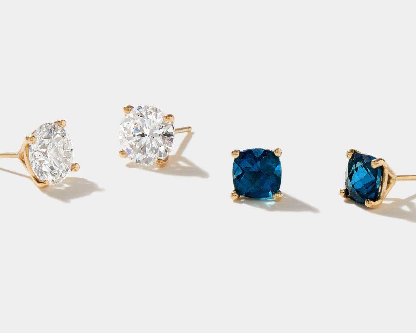 Lab grown diamond stud earrings in 14k gold with round white and blue stones.