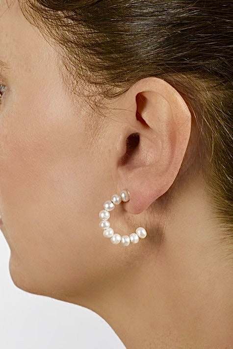 Stacked pearl hoops earrings with white freshwater cultured pearls on a 1-inch hoop worn on pierced ear