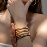 Hapur Gold Vermeil Bangle bracelet on woman's wrist showcasing slim, elegant design with diamond accents.