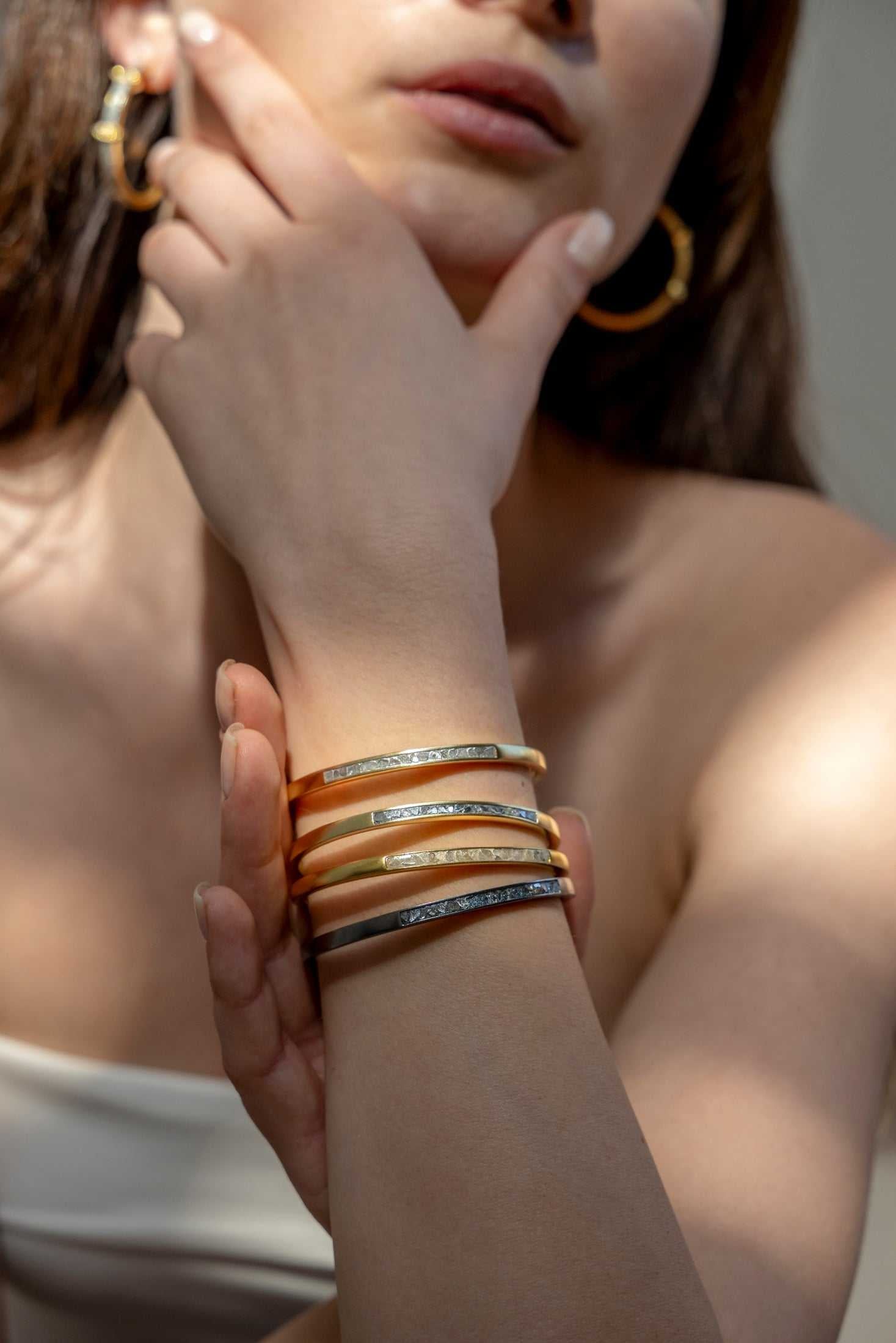 Hapur Gold Vermeil Bangle bracelet on woman's wrist showcasing slim, elegant design with diamond accents.