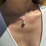 14K yellow gold pendant with 4.2 CT oval moissanite and 4 natural alexandrite stones in a vintage inspired mirror style worn on a delicate chain