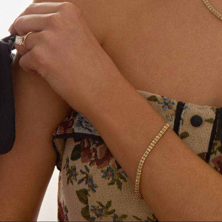 Tidal Tennis 14K Gold Bracelet on wrist with floral dress and ring showcasing Italian design and polished finish