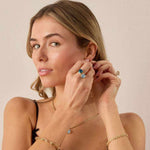 Woman wearing a London Blue Topaz 14k gold ring with cushion cut gemstone on her finger