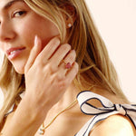 woman wearing lab grown diamond stud earrings with gold settings and a gold necklace with a bow on her shoulder