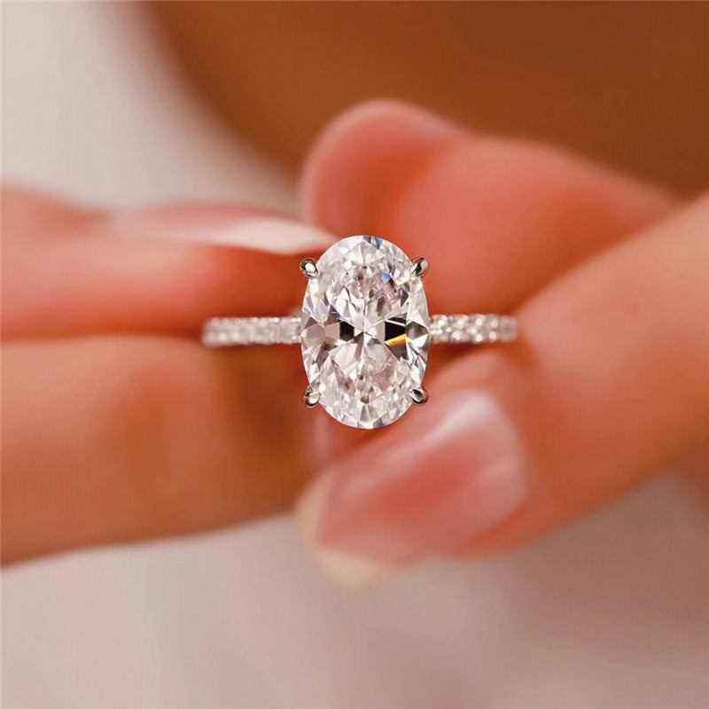 2.1 CTW DEW colorless oval brilliant cut moissanite solitaire engagement ring in sterling silver with pavé accents