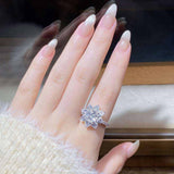 2.4 CTW DEW cushion cut moissanite sunflower halo engagement ring in sterling silver worn on finger