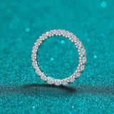 2.1 CTW DEW full round moissanite eternity wedding band in platinum plated sterling silver on sparkling turquoise background