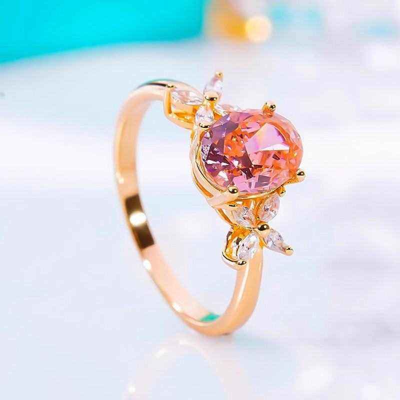 Oval cut pink moissanite three-stone engagement ring with four leaf flower accents in 18K rose gold plated sterling silver