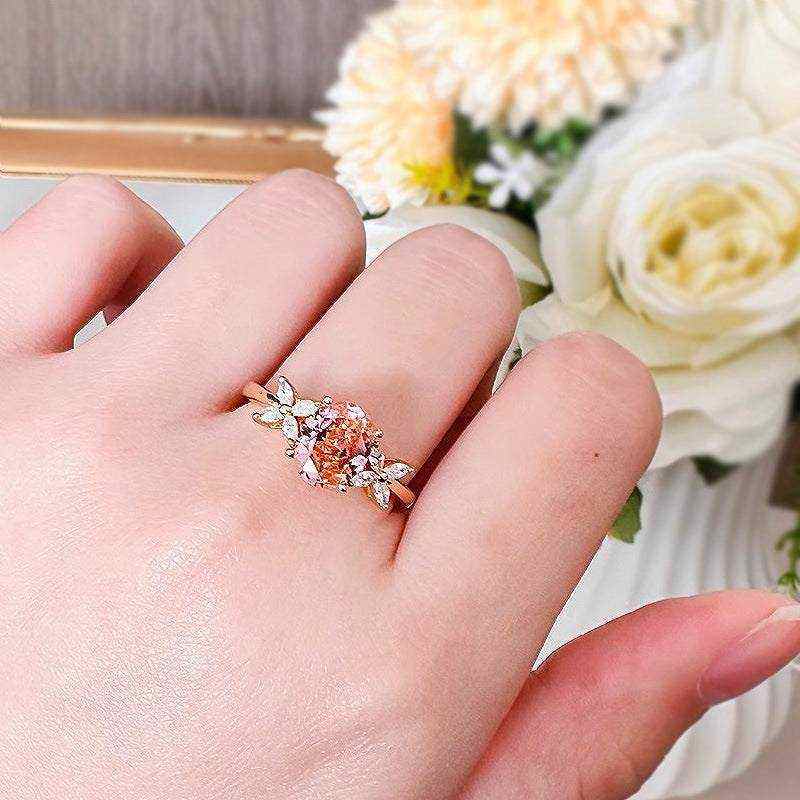 Oval cut pink moissanite three-stone engagement ring with flower accents in 18K rose gold plated sterling silver on hand