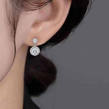 Close-up of ear wearing 1 CTW DEW colorless round cut moissanite halo drop earring in 925 sterling silver with push back stud