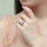 1 CTW DEW colorless round brilliant cut moissanite sterling silver twist pavé halo engagement ring on finger