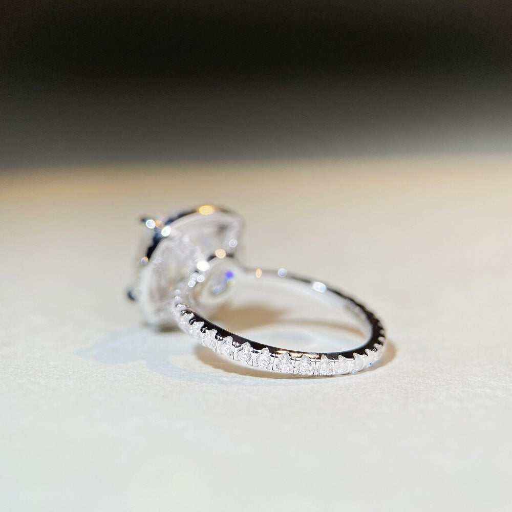 Sterling silver pavé halo engagement ring with 5 CTW colorless cushion cut moissanite and cubic zirconia accents