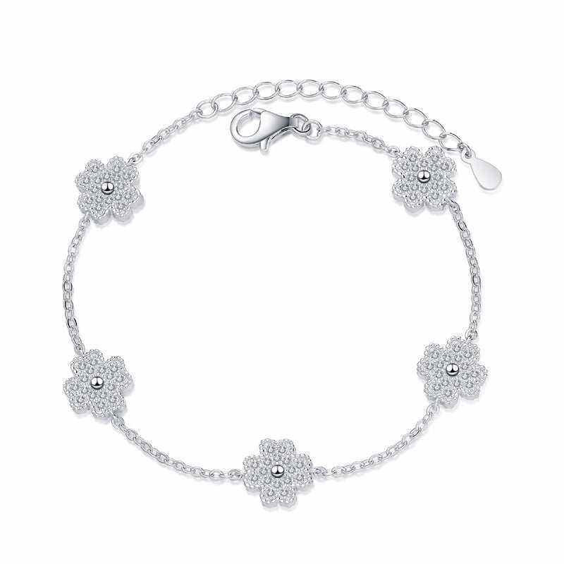 Adjustable 925 sterling silver bracelet with five colorless melee moissanite lucky clover freesia flower charms totaling 0.64 ct. tw. on a rolo chain