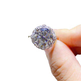 4.75 CTW DEW colorless round brilliant cut moissanite halo engagement ring in sterling silver held by hand