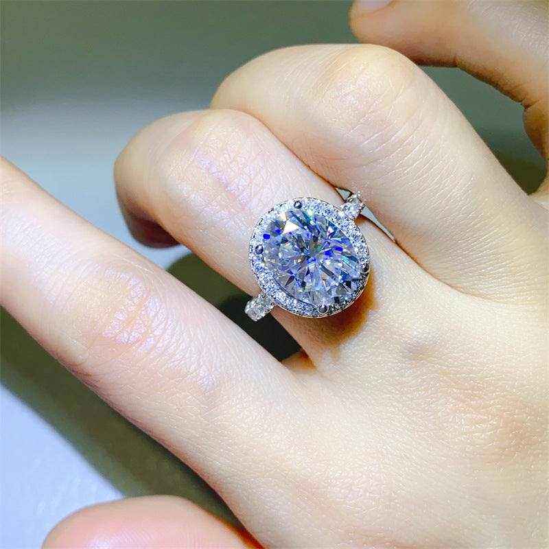 4.2 CTW DEW colorless oval brilliant cut moissanite halo engagement ring in sterling silver on hand