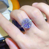 4.75 CTW DEW moissanite halo engagement ring in sterling silver worn on finger