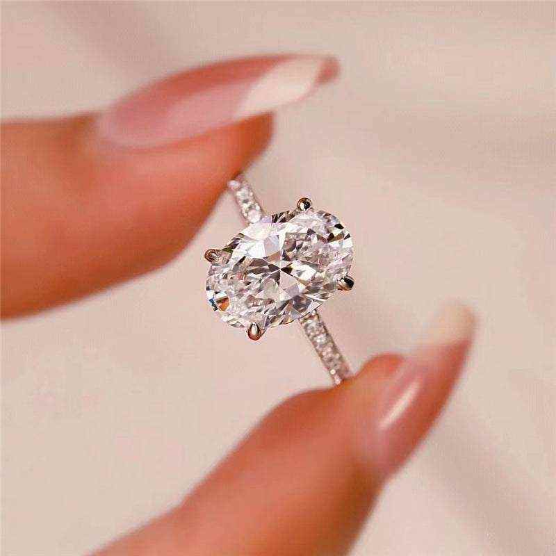 2.1 CTW DEW colorless oval brilliant cut moissanite solitaire engagement ring in sterling silver with pavé setting
