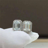 Pair of 1.05 CTW DEW emerald cut rectangular colorless moissanite halo stud earrings in 925 sterling silver with push back closures
