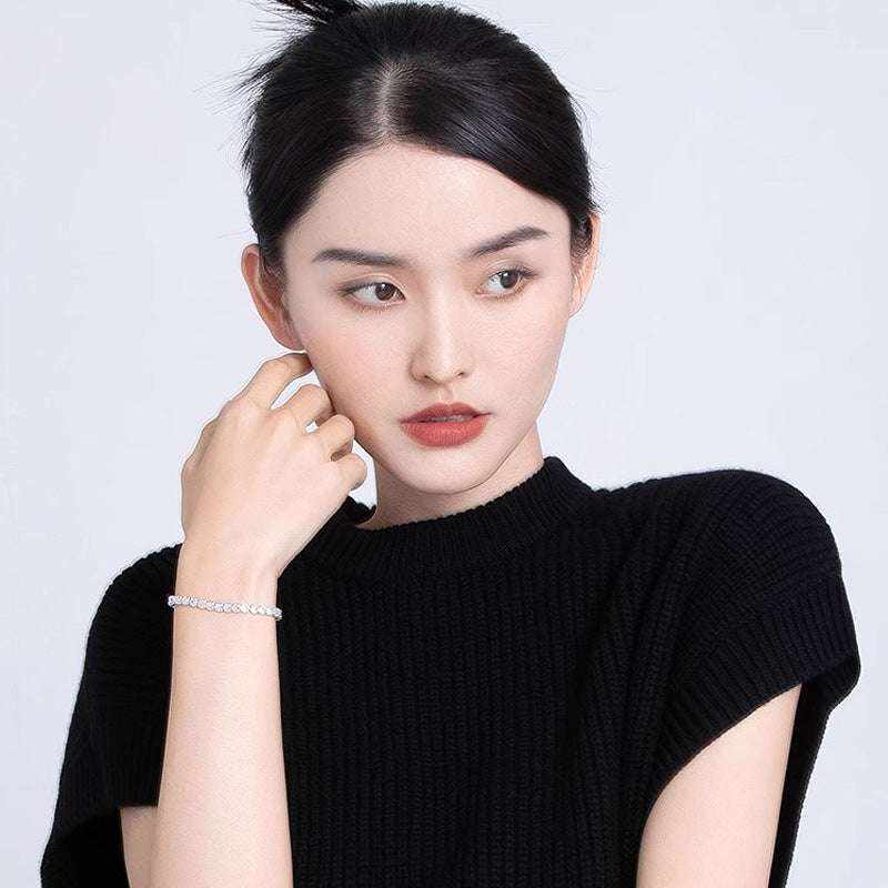 Woman wearing 3.5 CTW colorless round brilliant cut moissanites tennis bolo bracelet in adjustable 925 sterling silver bond