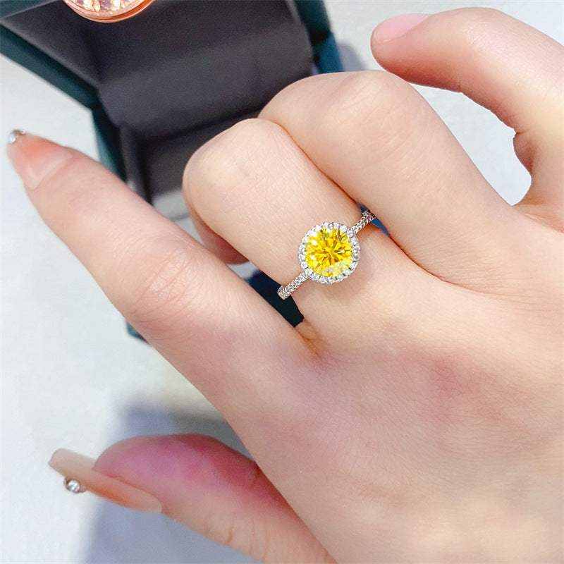 Hand wearing 4.75 CTW DEW round brilliant cut fancy yellow moissanite sterling silver pavé halo engagement ring