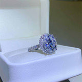 4.2 CTW DEW colorless oval brilliant cut moissanite engagement ring in sterling silver with pavé halo and braided design