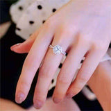 1 CTW DEW colorless round brilliant cut moissanite sterling silver twist pavé halo engagement ring on hand