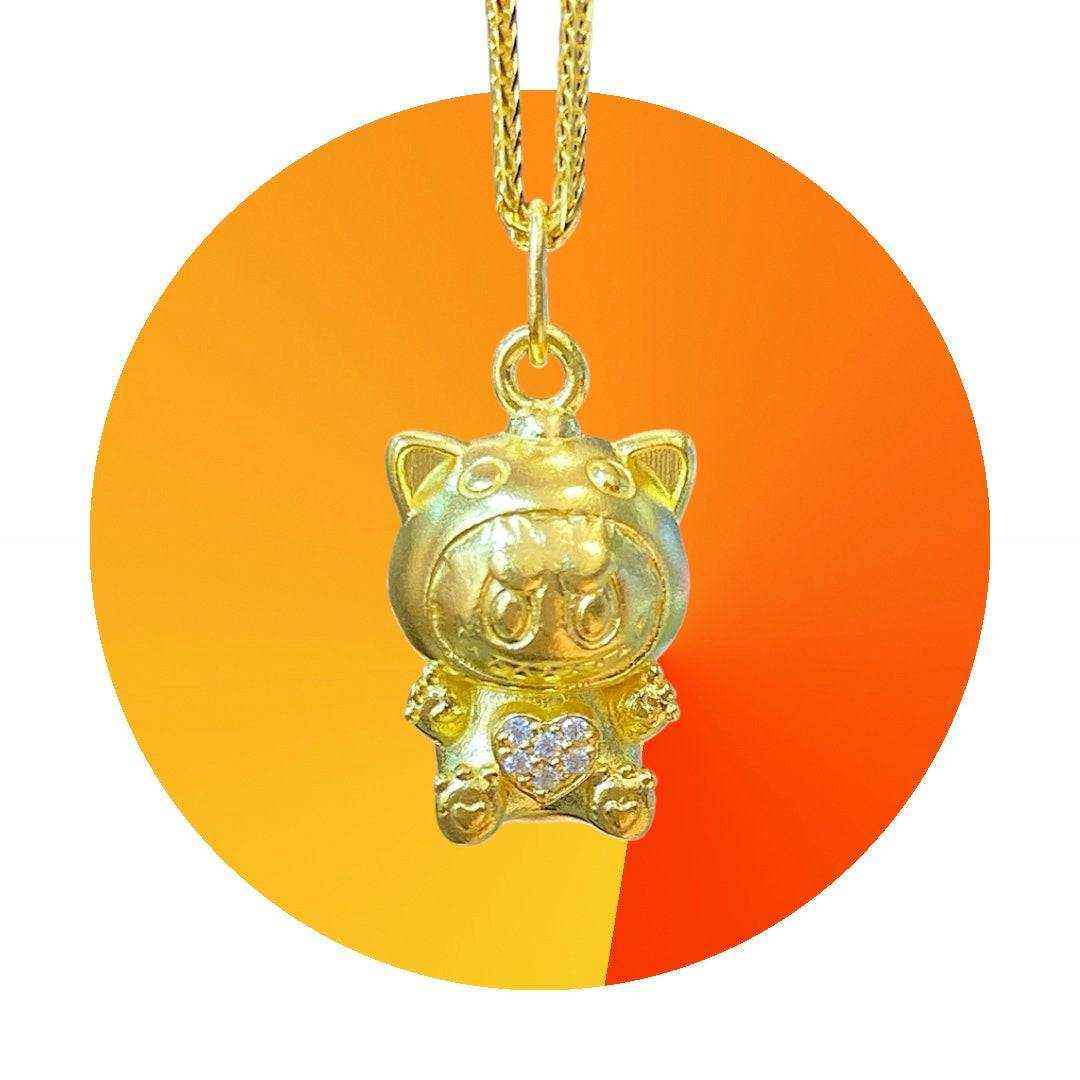 24K gold Labubu-inspired pendant with heart-shaped moissanite stones on a gold chain against orange background