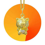 24K gold Labubu-inspired pendant with heart-shaped moissanite stones on a gold chain against orange background