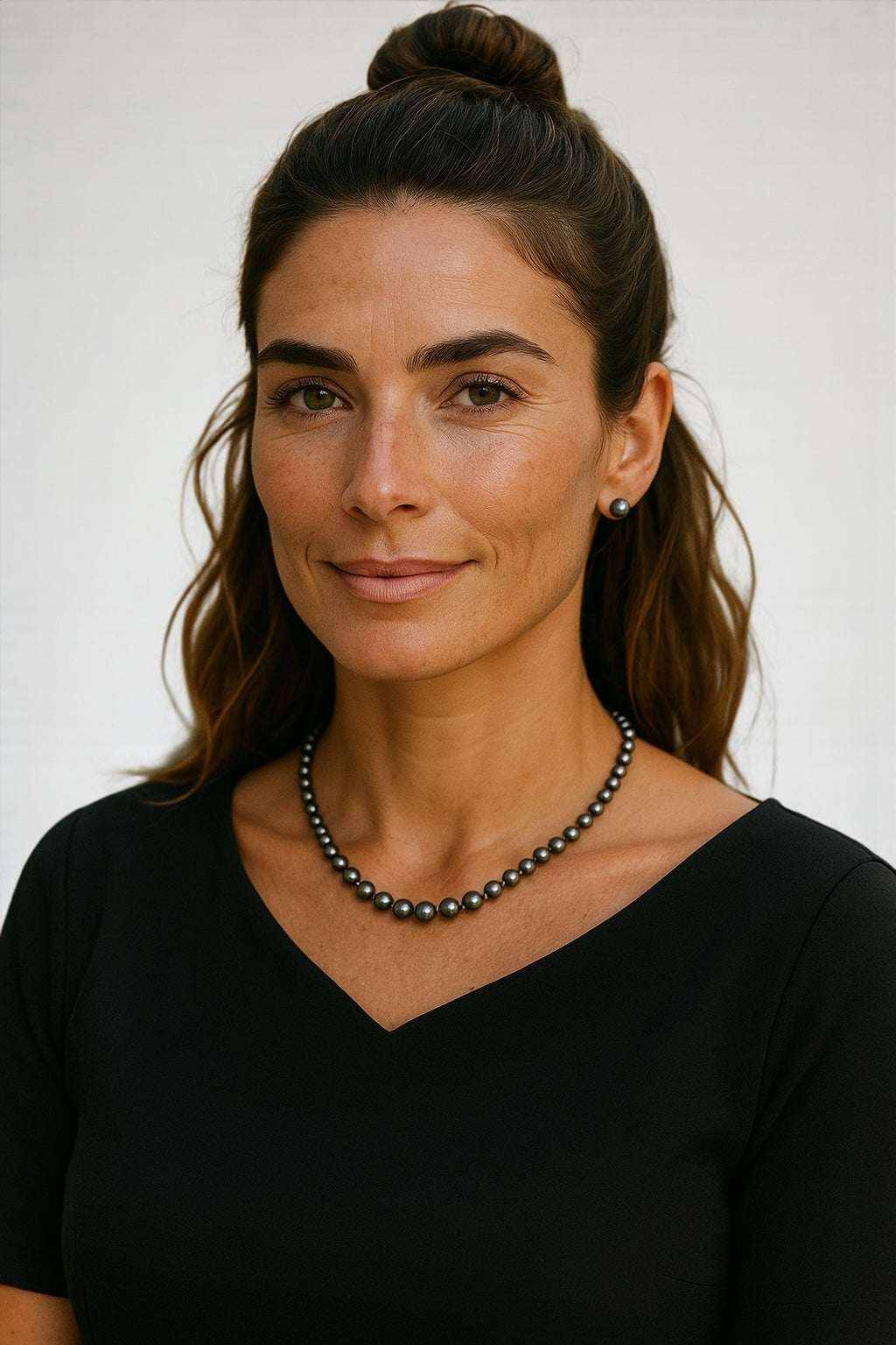 Woman wearing elegant black freshwater pearl strand necklace with stainless steel clasp