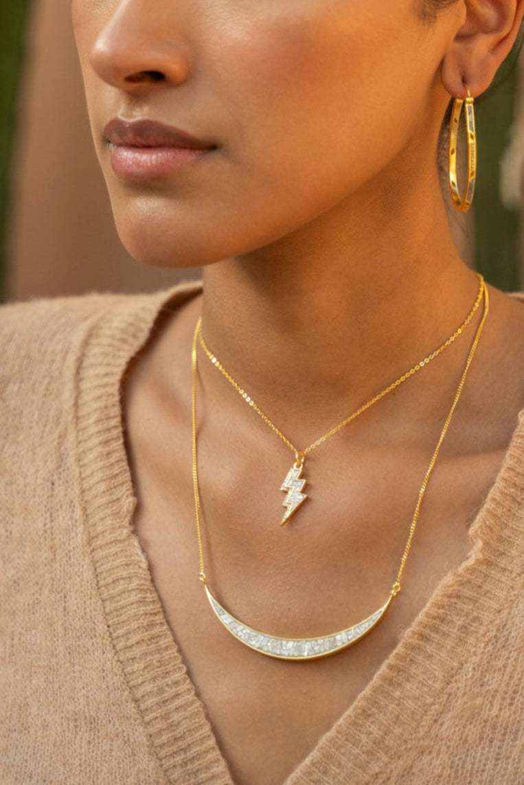 Rishi Bolt Diamond gold vermeil pendant necklace on woman wearing hoop earrings and beige top