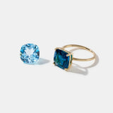 14k gold ring with cushion cut London Blue Topaz gemstone and loose light blue topaz stone on white background