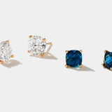 Tide Earrings featuring cushion cut London blue topaz and white gemstones set in 14k yellow gold stud mounts.