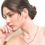 Woman wearing Alex Gold Vermeil stud earrings with layered gold and silver necklaces