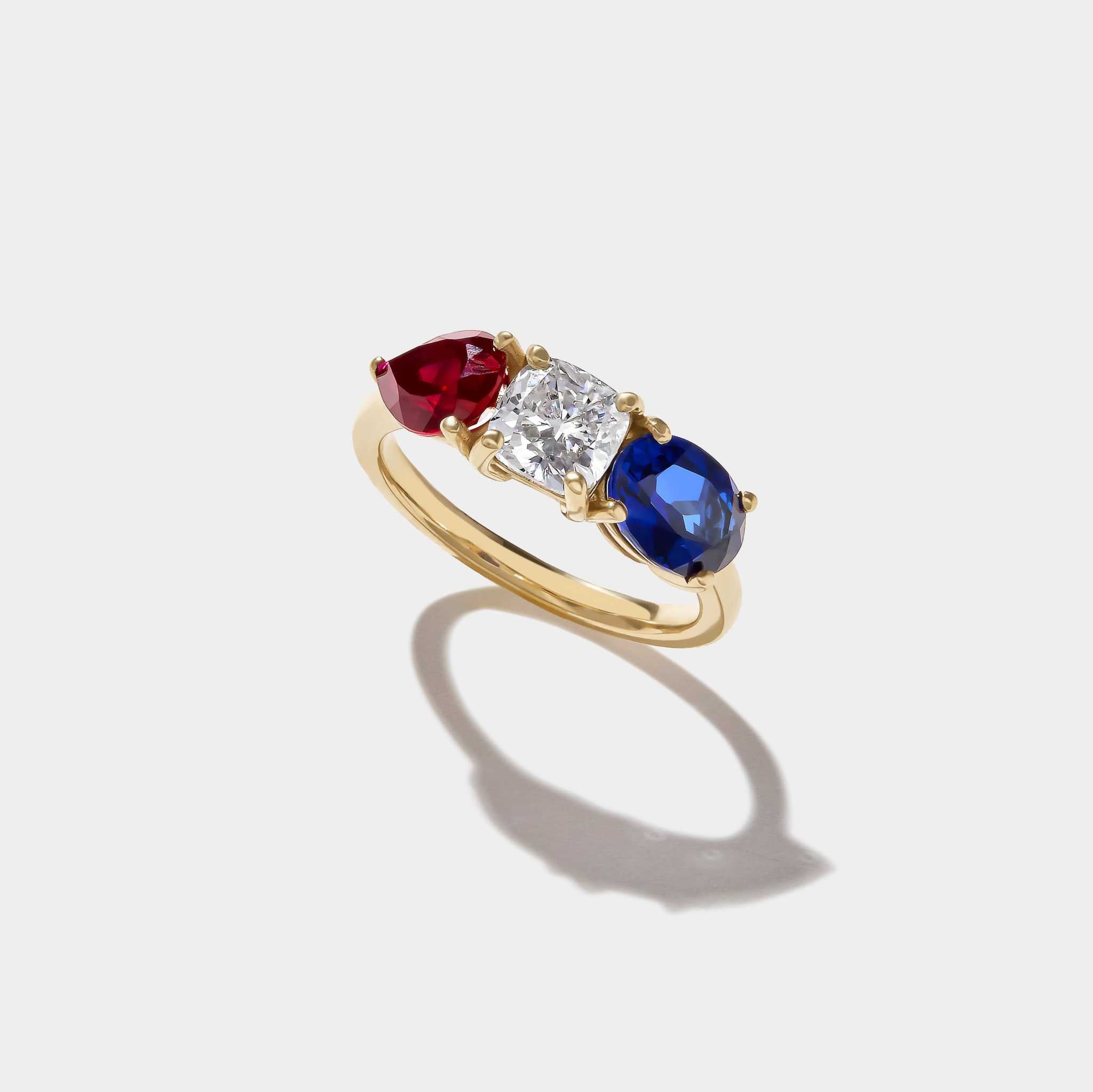 Americana Signature Three-Stone Ring with lab-grown ruby, cushion-cut diamond, and sapphire set in 14k yellow gold