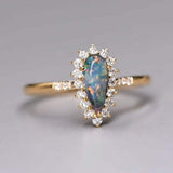 18K yellow gold engagement ring with Australian black opal and halo diamonds