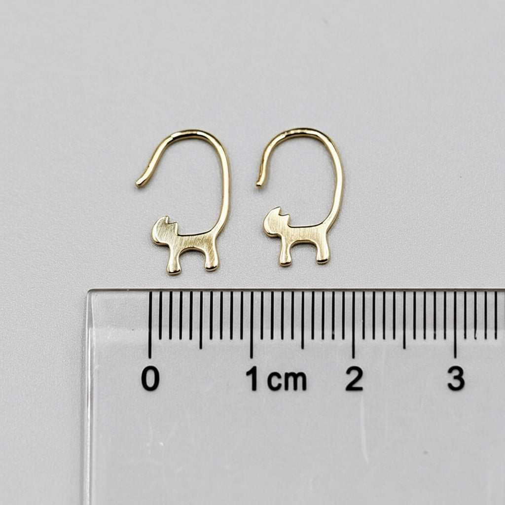 18k yellow gold cat tail hook earrings with drop style shown next to centimeter ruler for size reference