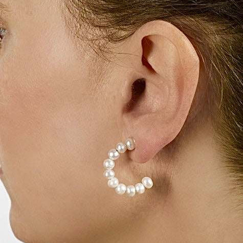 Stacked pearl hoops earrings with white freshwater cultured pearls on a 1-inch hoop worn on pierced ear