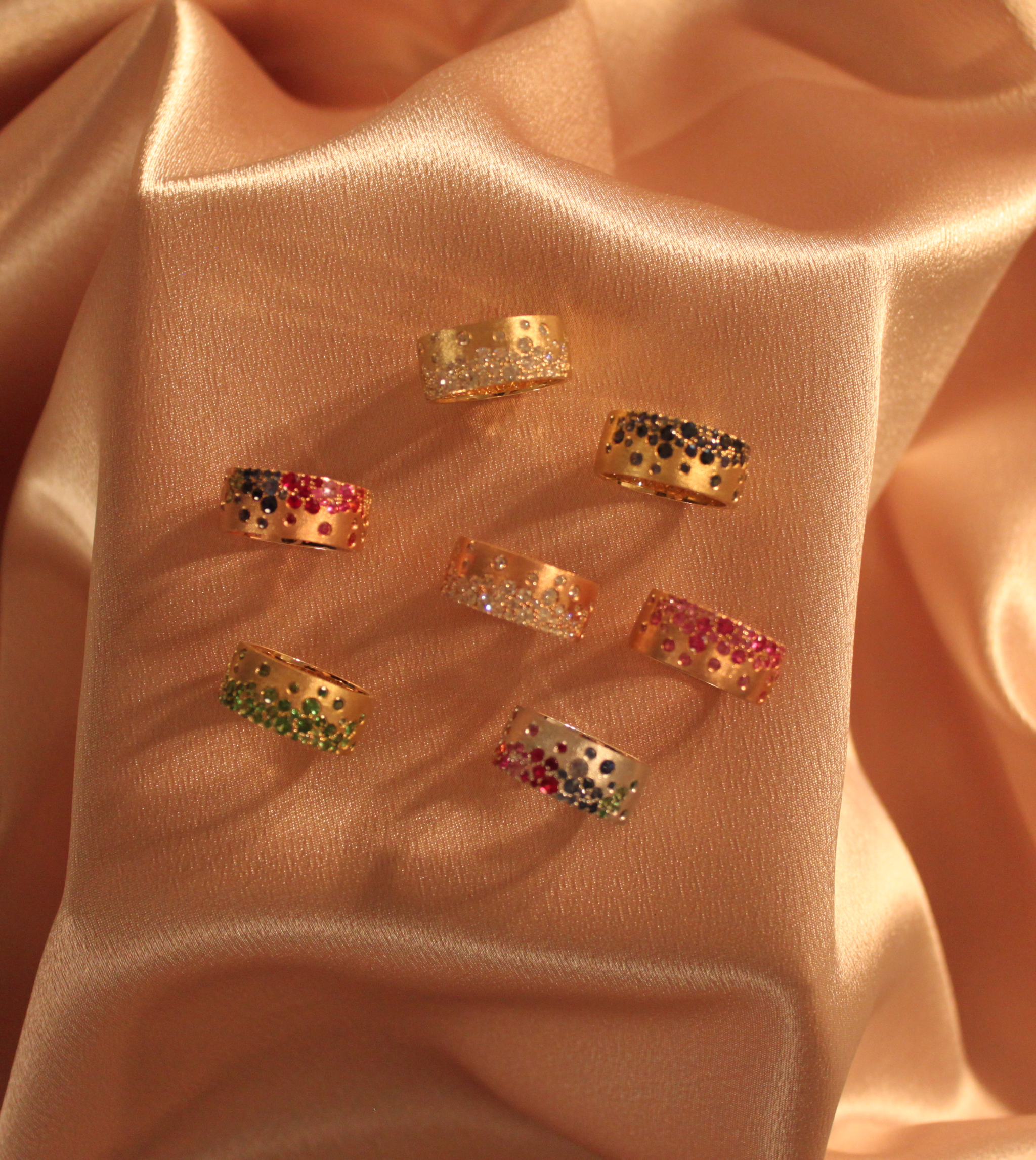 14K gold sapphire scattered rainbow cigar bands with satin brushed finish on silky fabric